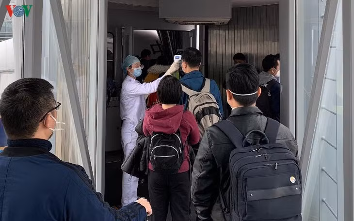 Kiểm tra thân nhiệt hành khách trước khi lên máy bay tại một sân bay Trung Quốc.