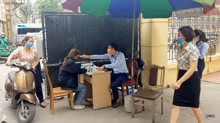 Người dân đến giao dịch trực tiếp tại Trung tâm Hành chính công TP Cẩm Phả được kiểm soát y tế chặt chẽ.