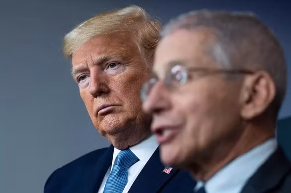 Tổng thống Donald Trump đứng sau bác sĩ Anthony Fauci trong buổi họp báo ngày 21/3/2020 tại Nhà Trắng kể về cách dùng thuốc chống sốt rét trị Covid-19 - Ảnh: AFP.