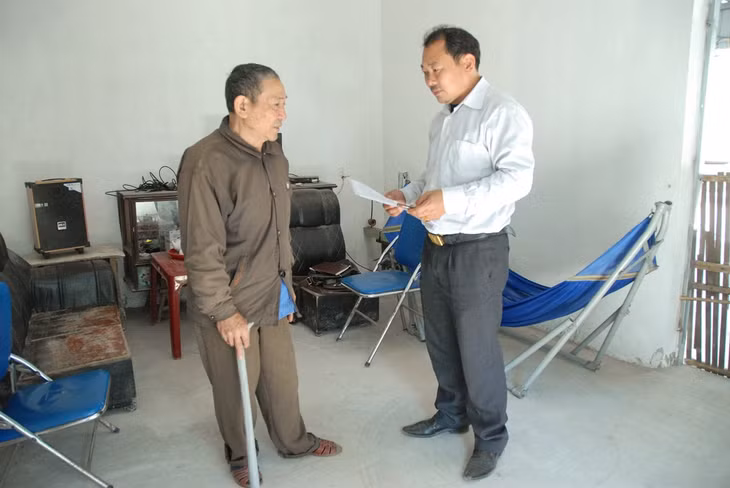 Cán bộ xã Quảng An, huyện Đầm Hà (phải) nắm tình hình hộ dân sau khi tự viết đơn đăng ký thoát nghèo.