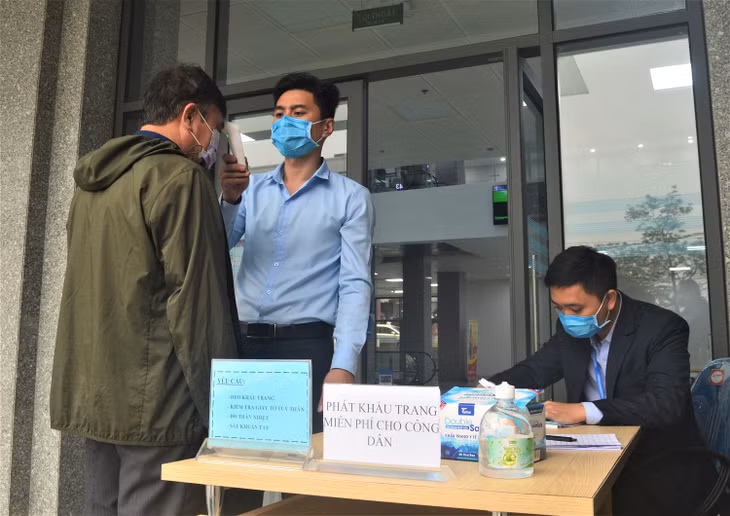 Người dân được đo thân nhiệt trước khi vào làm việc tại Trung tâm Phục vụ hành chính công tỉnh. 