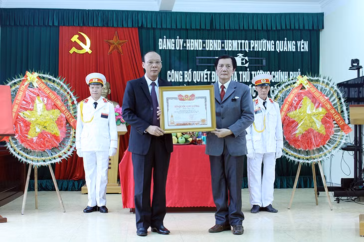 Lãnh đạo TX Quảng Yên (trái) trao Bằng tổ quốc ghi công cho liệt sĩ Đoàn Kim Ngân
