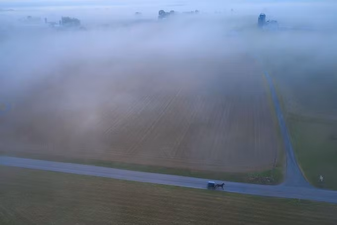 Bức ảnh “Foggy Morning in Amish Country” (tạm dịch Sáng mù sương ở vùng đất của người Amish), chụp bởi tác giả Juan Osorio. Tác phẩm vào chung kết chủ đề ảnh Trải nghiệm nước Mỹ chụp cảnh chiếc xe ngựa kéo chở gia đình người Amish đến dự lễ nhà thờ tại làng Strasburg, hạt Lancaster, bang Pennsylvania, Mỹ, ngang qua một trang trại phủ đầy sương sớm.