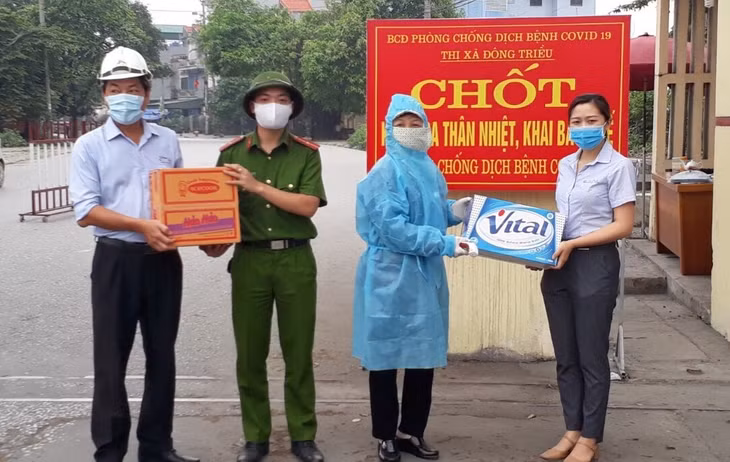 Đại diện Công ty Xi măng VICEM Hoàng Thạch trao nước uống và mỳ tôm cho chốt liên ngành kiểm soát dịch bệnh Covid-19.