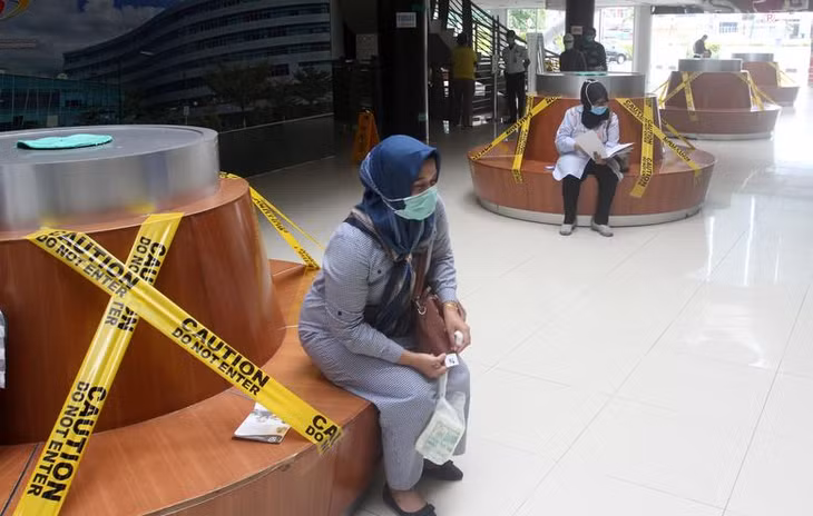 Du khách ngồi theo chỗ được chỉ định tại ghế chờ trong bệnh viện Padang, Indonesia. Ảnh: Reuters