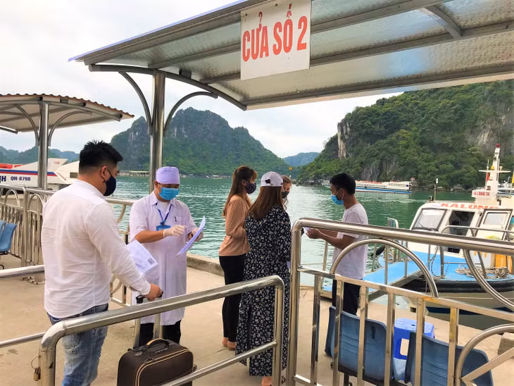Cán bộ y tế và thuyền trưởng kiểm tra tờ khai y tế, vé tàu trước khi người dân xuống tàu. 