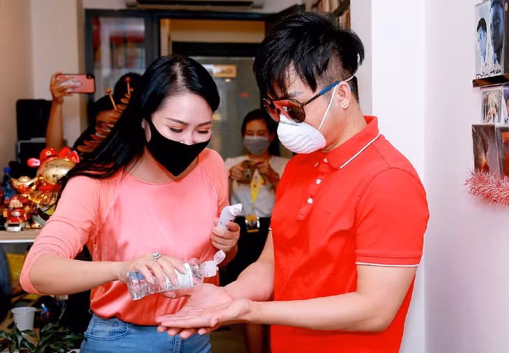 Các nghệ sĩ sát khuẩn tay trước khi vào phòng thu. Ảnh: Thanh Tú.