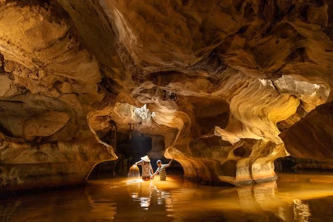"Cave Fishing" (Bắt cá trong hang động) của tác giả Natnattcha Chaturapitamorn (Thái Lan) vào chung kết chủ đề ảnh Du lịch, chụp hai cha con dùng nơm bắt cá tại một hang động ở Kiên Lương, Kiên Giang, Việt Nam.
