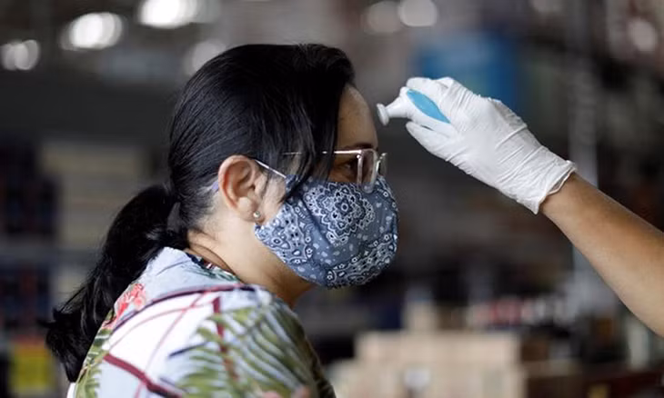 Người phụ nữ được kiểm tra thân nhiệt tại Brasilia hôm 20/3. Ảnh: Reuters.