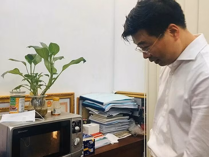 Ông Hải hướng dẫn cách tiệt khuẩn khẩu trang bằng lò vi sóng. Ảnh: Lê Nga.