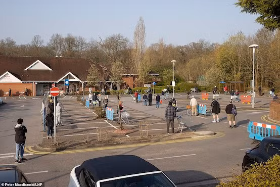 Khách hàng giữ khoảng cách khi xếp hàng bên ngoài siêu thị Tesco tại thị trấn Leatherhead, hạt Surrey (Anh). Ảnh: Daily Mail
