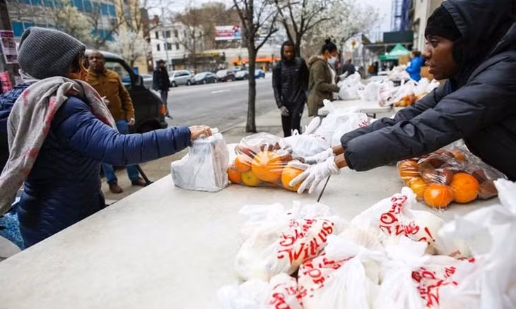Tình nguyện viên của tổ chức từ thiện City Harvest phân phối thực phẩm tại New York. Ảnh: AFP.