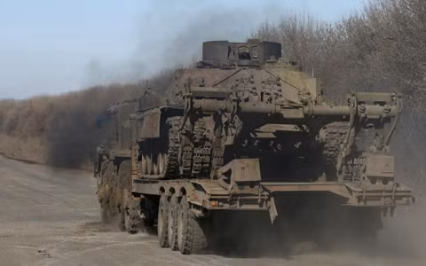 Một chiếc xe quân sự chở một chiếc xe tăng bị bắn hỏng ở miền đông Ukraine (ảnh: Reuters)