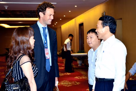 Phó Chủ tịch UBND tỉnh Nguyễn Văn Thành (ngoài cùng, bên phải) trao đổi với nhà đầu tư bên lề Hội nghị công bố các quy hoạch chiến lược tỉnh Quảng Ninh, tháng 9-2014.