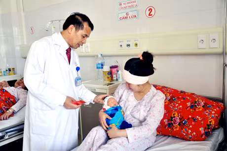 Bác sĩ Đỗ Văn Thinh, Trưởng Khoa Sản thăm, mừng tuổi cho bé Đoàn Gia Bảo - cháu bé đầu tiên ra đời trong năm Ất Mùi tại Bệnh viện Sản - Nhi tỉnh.