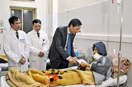 Đồng chí Nguyễn Văn Đọc động viên và tặng quà cho bệnh nhân phải nằm viện trong dịp Tết.