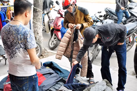 Các cửa hàng thời trang đổ đống trên vỉa hè bán đại hạ giá có rất đông người mua.