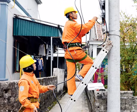 Công nhân Điện lực Vân Đồn lắp đặt công tơ mới cho người dân xã Minh Châu.
