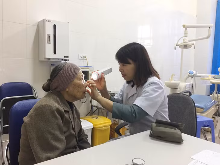 Bác sĩ TTYT huyện Đầm Hà khám bệnh cho người dân.
