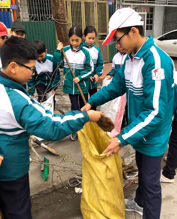 Học sinh trường THCS Hà Tu thực hiện dọn vệ sinh môi trường quang khu vực trường học và khu dân cư.