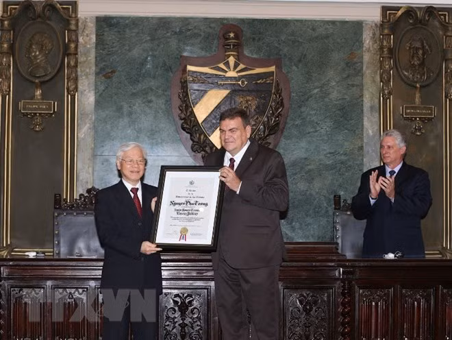 Hiệu trưởng trường Đại học Tổng hợp La Habana trao bằng Tiến sỹ Danh dự khoa học Chính trị và Quyết định cho Tổng Bí thư Nguyễn Phú Trọng. (Ảnh: Trí Dũng/TTXVN)