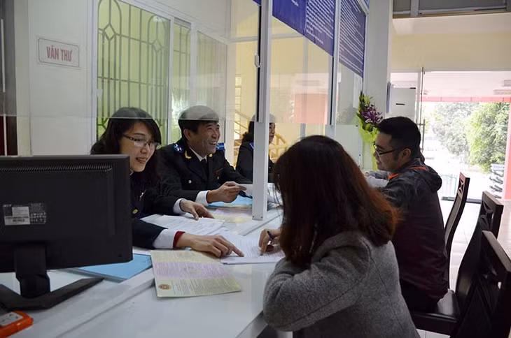 Cán bộ Bộ phận một cửa, Cục THADS tỉnh, hướng dẫn người dân giải quyết thủ tục liên quan đến công tác THADS. Ảnh: Nguyễn Chiến