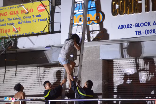 Chiến sĩ cứu hỏa hỗ trợ nạn nhân trong vụ cháy. Ảnh: Lê Trai.