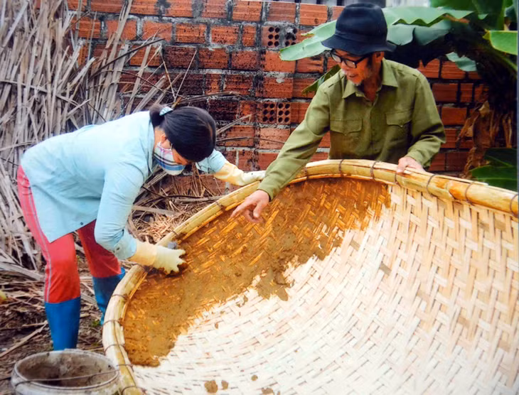 Nghệ nhân Nguyễn Văn Giót chỉ bảo con dâu thực hiện một công đoạn làm thuyền nan.