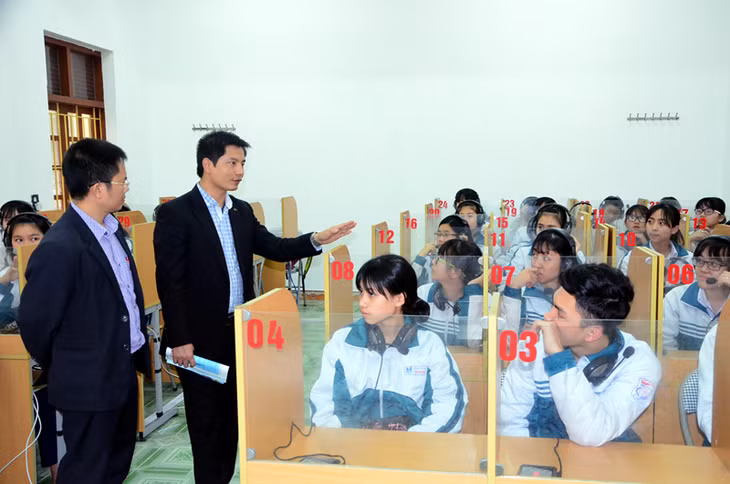 Tiến sĩ Nguyễn Ngọc Hải, Bí thư Đảng uỷ, Hiệu trưởng Trường THPT Uông Bí (đang giơ tay) giới thiệu mô hình dạy và học tiếng Anh theo chương trình mới trong trường. Ảnh: Tạ Quân