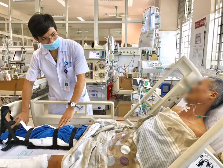 Bác sĩ thăm khám chân cho người bệnh sau phẫu thuật thay động mạch nhân tạo