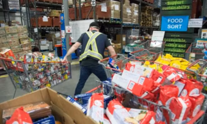 Nhân viên của GVFB vận chuyển hàng hóa tại Burnaby, British Columbia, Canada, hôm 18/3. (Ảnh: The Canadian Press)