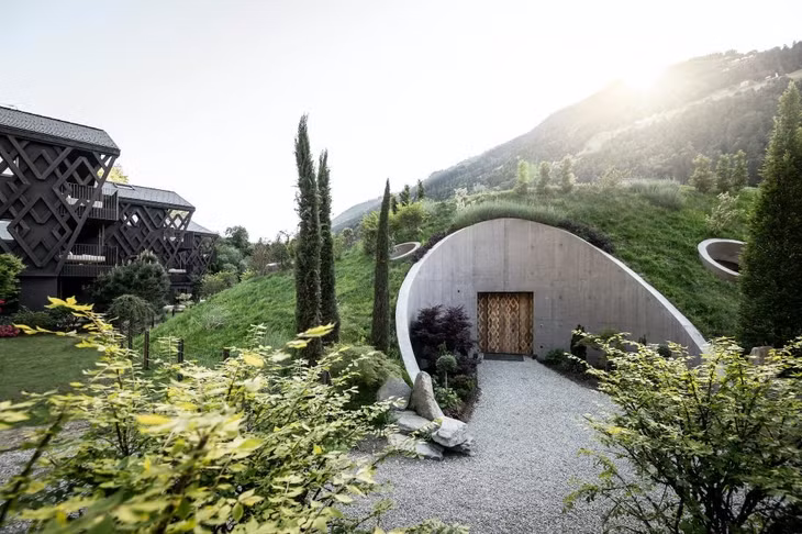Khách sạn chỉ có 40 phòng, trước đó vào tháng 5 Apfelhotel Torgglerhof mới mở rộng để có thêm 18 phòng suite, một nhà hàng lớn và khu spa. Trên hình là cổng vào khu spa làm từ bê tông kết hợp các thảm cỏ xanh dựa theo kiểu nhà của người lùn Hobbit. Kiến trúc hòa hợp thiên nhiên này hiện khá phổ biến ở các khu nghỉ dưỡng và nhà nghỉ dạng Airbnb trên thế giới.