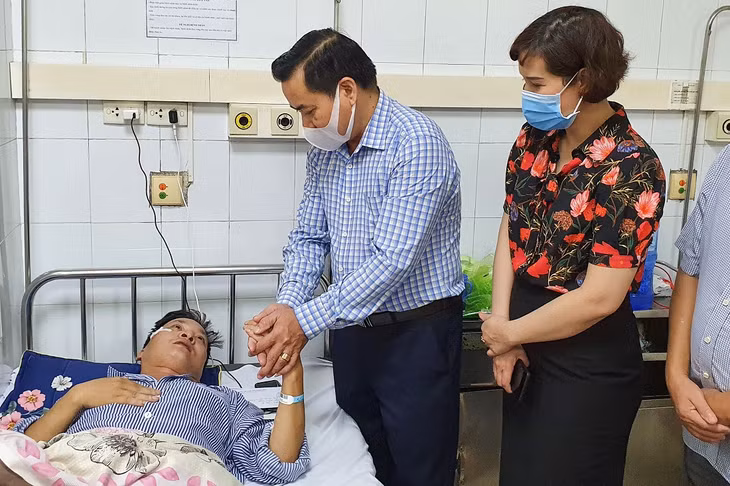 Đồng chí Hoàng Đức Hạnh, Phó Chủ tịch Ủy ban MTTQ tỉnh (trái) thăm hỏi nạn nhân đang điều trị tại Bệnh viên Đa khoa tỉnh.