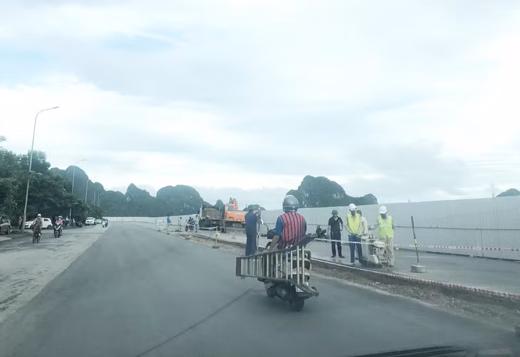 Người tham gia giao thông vừa điều khiển xe máy vừa mang vật cồng kềnh gây mất an toàn giao thông. Chụp tại đường Trần Quốc Nghiễn, TP Hạ Long.
