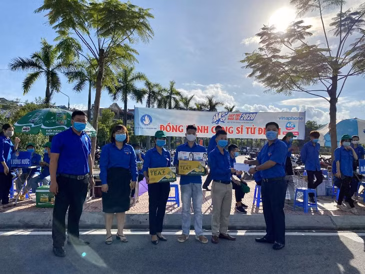 Đại diện BTV tỉnh đoàn tặng quà cho đội hình thanh niên tình nguyện Tiếp sức mùa thi tại điểm thi trường THPT Hoành Bồ, TP Hạ Long.