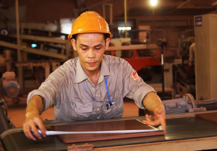 Cán bộ kỹ thuật kiểm tra kích cỡ một sản phẩm gốm.