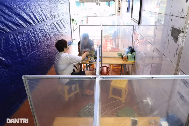 Tại một quán phở trên đường Tôn Đức Thắng, giữa các bàn to được dựng những tấm ngăn chia làm 4 góc; bàn nhỏ chia làm 2 ngăn, mỗi ngăn dành cho một người. Khách hàng vẫn có thể nhìn thấy nhau và trò chuyện qua vách ngăn trong suốt.