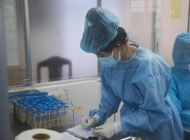 Nhân viên phòng xét nghiệm (CDC Đà Nẵng) ghi chép lại tên của từng mẫu xét nghiệm. Ảnh minh họa: TTXVN.