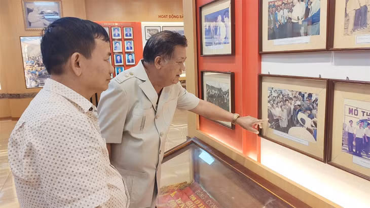 Ông Vũ Ngọc Thấn (bên phải), nguyên Chánh Văn phòng Công ty CP Than Cọc Sáu và ông Đoàn Trường Ánh, Phó Chủ tịch Công đoàn, nguyên Bí thư Đoàn Thanh niên Công ty CP Than Cọc Sáu ôn lại kỷ niệm ngày Tổng Bí thư Lê Khả Phiêu về thăm Mỏ qua bức ảnh được treo trang trọng trong Phòng Truyền thống.