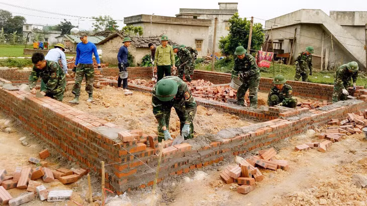 Không khí nhiệt tình của cán bộ, chiến sỹ Lâm trường 103 giúp dân xây dựng nhà ở mới.