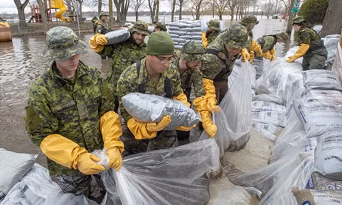 Binh sĩ đắp cát ngăn lũ tràn vào nhà dân ở Laval, tỉnh Quebec hôm 25/4. Ảnh: Canadian Press.
