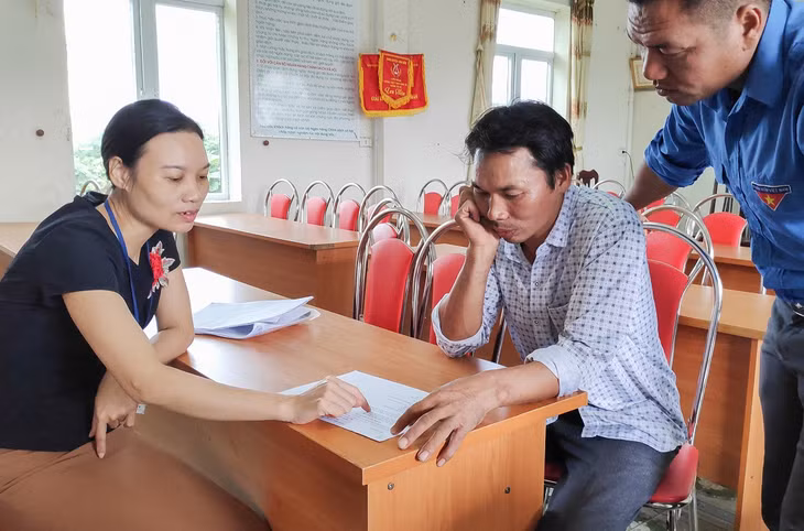 Cán bộ xã Đài Xuyên (Vân Đồn) giải đáp cho người dân về chính sách hỗ trợ hộ nghèo. 