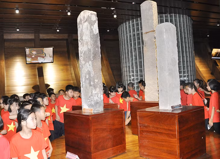 Các em học sinh tham quan cột mốc cổ trưng bày tại Bảo tàng Quảng Ninh.
