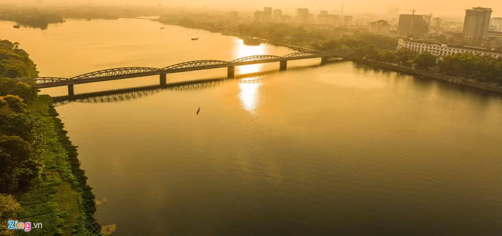  Lúc này cầu Trường Tiền như chiếc lược ngà cài trên mái tóc thiếu nữ Huế trong nắng mai.