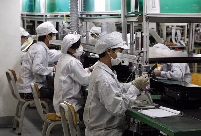  Các công nhân làm việc trên dây chuyền lắp ráp của Foxconn. Ảnh: Bloomberg