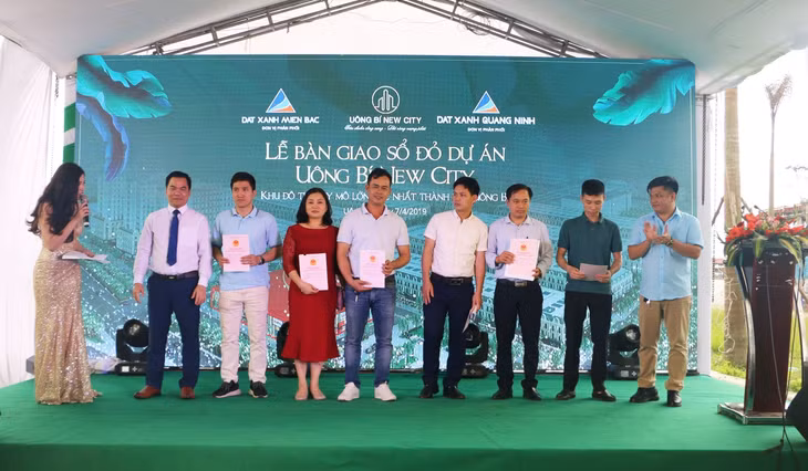 Đại diện chủ đầu tư Tân Thành - ông Nguyễn Hoàng Long trao sổ đỏ dự án Uông Bí New City cho khách hàng.