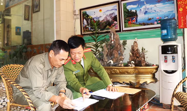 Ông Trần Xuân Tâm, Tổ trưởng Tổ tuần tra nhân dân khu 5A bàn bạc phương án tuần tra với cảnh sát khu vực 