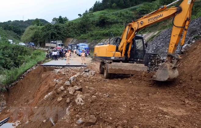 Công ty quản lý và xây dựng cầu đường 3 khẩn trương khắc phục đoạn đường bị đứt do mưa lũ gây ra tại km 369, quốc lộ 32 huyện Tân Uyên đi Than Uyên. (Ảnh: Quý Trung/TTXVN)