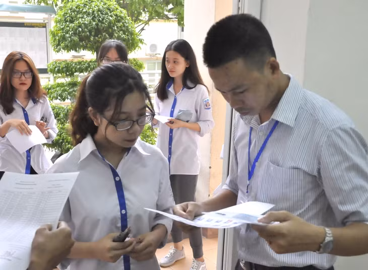 Cán bộ coi thi kiểm tra thẻ dự thi của thí sinh. Ảnh chụp điểm thi THPT Hòn Gai.