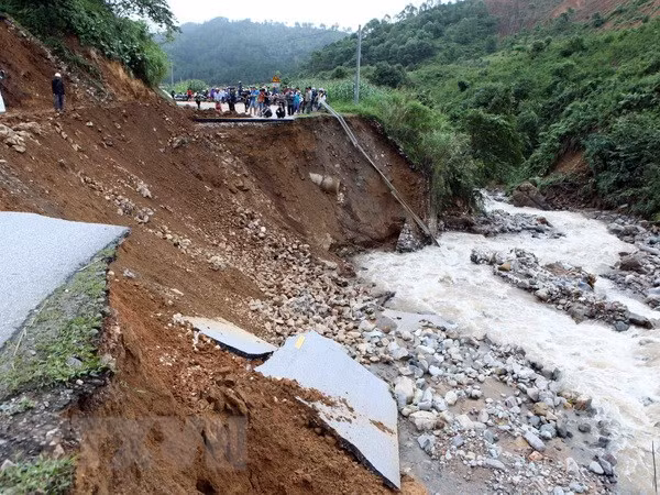 Đoạn đường bị đứt 30m do mưa lũ gây ra tại km 369, quốc lộ 32 huyện Tân Uyên đi Than Uyên khiến giao thông chia cắt. (Ảnh: Quý Trung/TTXVN)